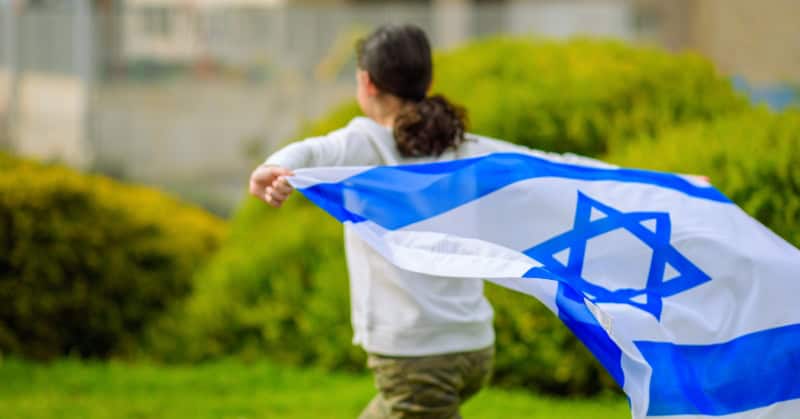 ילדה שמחה עם דגל ישראל